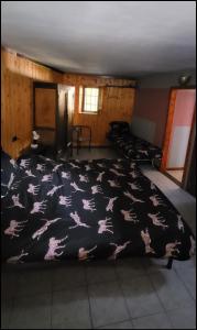 een slaapkamer met een zwarte deken met paarden erop bij '' Al Pèrgul '' in Civo