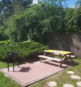 a picnic table and a trash can on a brick walkway at domik in Lapmežciems