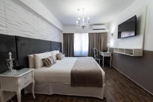 Schlafzimmer mit einem Bett, einem Schreibtisch und einem TV in der Unterkunft Ker San Telmo Hotel in Buenos Aires