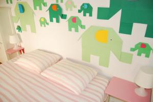 1 dormitorio con 1 cama y una pared con elefantes en Ku Apartment, en Murcia