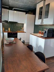 a kitchen with a wooden table and white cabinets at Loksapark1 in Loksa