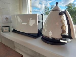 a microwave sitting on a counter next to a clock at Loksapark1 in Loksa