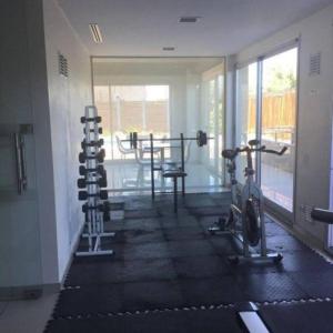 een fitnessruimte met hometrainers en een tafel in een kamer bij Hermoso departamento en complejo residencial in Tigre
