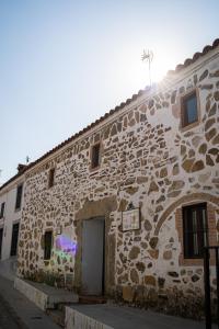 kamienny budynek z drzwiami na boku w obiekcie Nidal del Búho Casa Rural w mieście Azuel