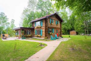 ein kleines Blockhaus in einem Hof mit Bürgersteig in der Unterkunft Li'l Ranch - Nature Lovers Retreat TEX MEX Log home in Wiarton