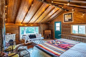 Li'l Ranch - Nature Lovers Retreat TEX MEX Log home في ويارتون: غرفة نوم كابينة خشب بها سرير وأريكة
