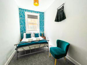 - une chambre avec un lit, une chaise et une fenêtre dans l'établissement Stunning 2 Bed Apt Nr The Royal Mile & The Castle, à Édimbourg