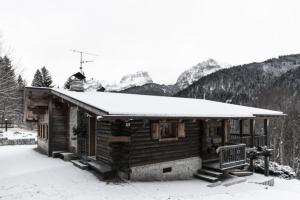 a log cabin with snow on top of it at Chalet Bait del Papi in Madonna di Campiglio +4 photos