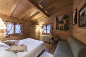 a bedroom with a bed and a couch in a room at Chalet Bait del Papi in Madonna di Campiglio