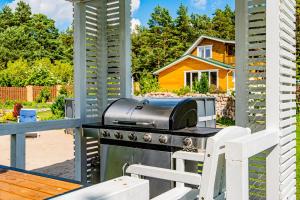 a grill on a patio with a table and chairs at Viski vila in Palanga