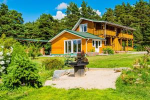 una casa de madera con un jardín delante de ella en Viski vila, en Palanga