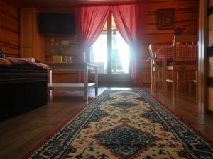 een woonkamer met een tafel en een tapijt bij PLITVICE MAGIC in Rudanovac