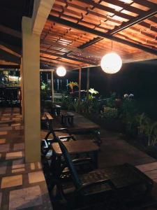 a restaurant with wooden tables and chairs and lights at Hotel Sunset Rooms in Tortuguero