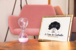 a clock sitting on top of a table with a glassico caffe calidad sign at A Casa de Carballo in Meis