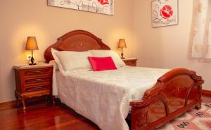 a bedroom with a bed with a red pillow on it at A Casa de Carballo in Meis