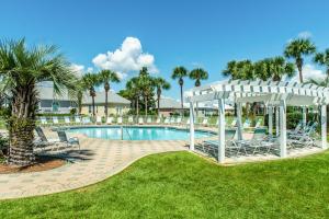 a pool at a resort with chairs and a pergola at Maravilla 3202 in Destin