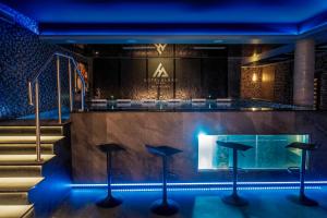 a lobby with a bar with stools and stairs at Hotel Alhar in Lubliniec