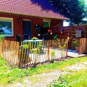 a wooden fence in front of a house at FeWo Unner'd Kastanje in Moormerland