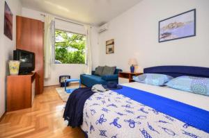1 dormitorio con cama, sofá y TV en Apartments Jana, en Makarska