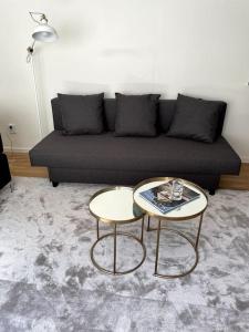 a living room with a couch and two tables at Exclusive guesthouse near the ocean in Hovås Gothenburg in Gothenburg