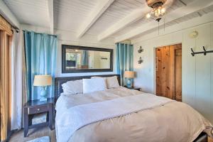 a bedroom with a large bed and blue curtains at Lakeview Lodge Fit for Groups Less Than 1 Mile to Lake! in Lake Arrowhead