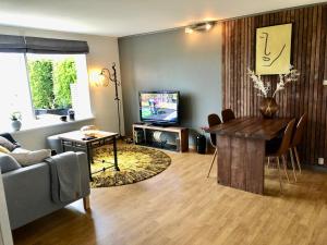 uma sala de estar com uma mesa e uma televisão em Cozy Landscape House em Strand