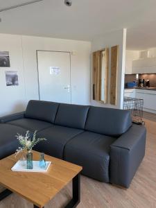 a living room with a blue couch and a table at Meehrblick App 215 in Zingst