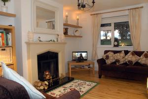 sala de estar con sofá y chimenea en Coolbeg Farmhouse, en Maguires Bridge