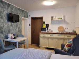 a living room with a kitchen and a table with chairs at Gästehaus Kampik in Witten