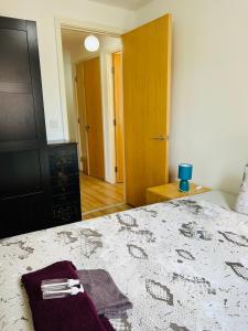 a bedroom with a bed with a purple towel on it at FABULOUS 2BED 2BATH Ground Floor SERVICED ACCOMMODATION Near CITY in Edinburgh