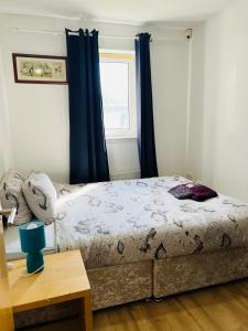 sypialnia z łóżkiem z niebieskimi zasłonami i oknem w obiekcie FABULOUS 2BED 2BATH Ground Floor SERVICED ACCOMMODATION Near CITY w Edynburgu