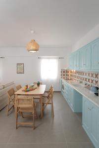 納克索喬拉的住宿－CASA DE SAL，厨房配有蓝色橱柜和桌椅