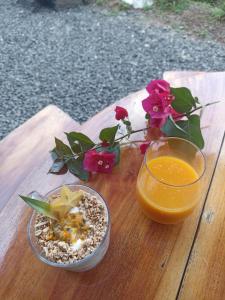 una mesa con un tazón de comida y un vaso de zumo de naranja en CASITA COLIBRIS, en Copecito
