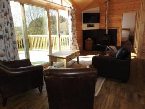 a living room with furniture and a large window at Birch Lodge, Pitlandie - Luxury 2 Bedroom Lodge with Sauna in Perth