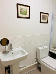 愛丁堡的住宿－FABULOUS 2BED 2BATH Ground Floor SERVICED ACCOMMODATION Near CITY，白色的浴室设有水槽和卫生间。