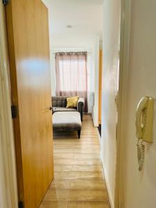 愛丁堡的住宿－FABULOUS 2BED 2BATH Ground Floor SERVICED ACCOMMODATION Near CITY，走廊上设有1间带沙发和电话的房间