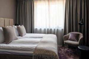 a bedroom with a bed and a chair and a window at Villa Lovik in Lidingö