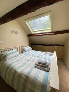 a bedroom with two beds and a window at Lavender Cottage - 18th Century Characterful Space 