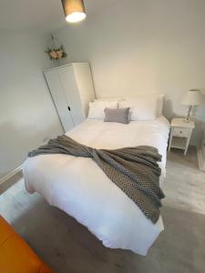 a bedroom with a white bed with a blanket on it at Serviced Accommodation in Hull