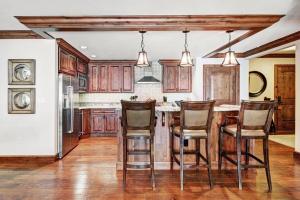 a kitchen with wooden cabinets and a kitchen island with chairs at Ritz Carlton Vail #200 condo in Vail