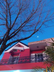czerwony budynek z balkonem na boku w obiekcie AltoRojo w mieście Villa Elisa