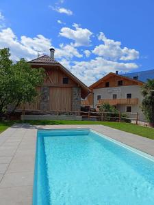 a blue swimming pool in front of a house at Torgglbauer Apartment 3 in Merano