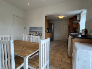 uma cozinha e sala de jantar com uma mesa de madeira em Sandymount House & Garden em Dublin