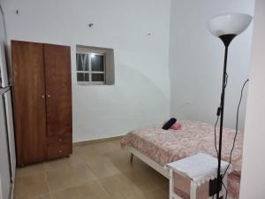 a bedroom with a bed and a lamp and a dresser at Tannous Aparthotel in Haifa