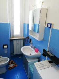 bagno blu con lavandino e servizi igienici di Casa Alessandria ad Alessandria