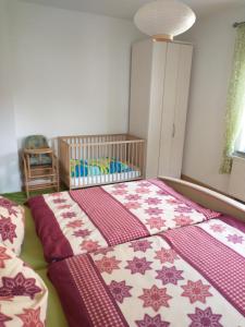 a bedroom with two beds and a crib at Ferienwohnung im Erzgebirge in Gelenau in Gelenau