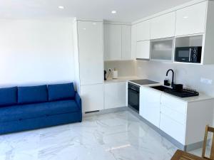 sala de estar con sofá azul en la cocina en L'Azor Suite Terrace - Praia das Mílicias, en Ponta Delgada
