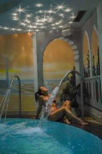 dos mujeres tumbadas en una piscina en una piscina en Hotel Alba Wellness & Spa, en Canazei