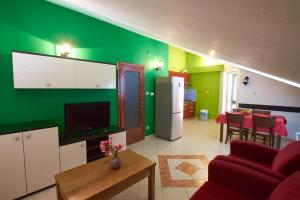 a living room with green walls and a red couch at Pansion HRGA in Vodice