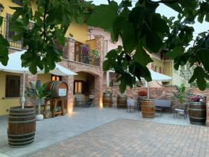 a courtyard of a building with chairs and umbrellas at La Cantina Rent Rooms in Agliè